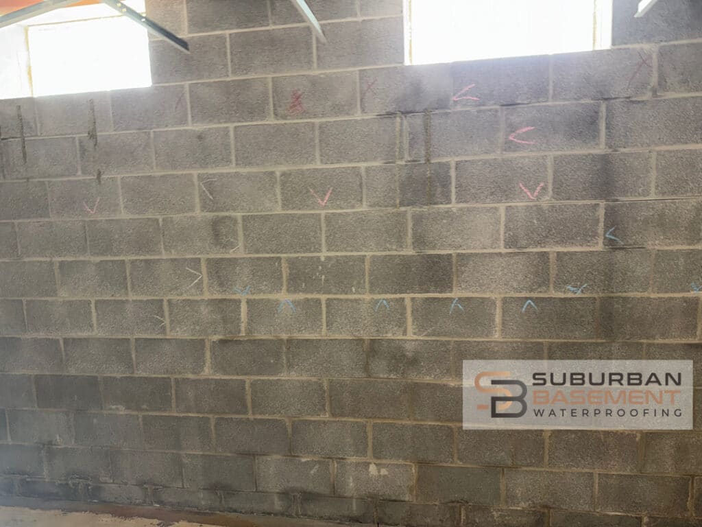 Water stained basement walls showing conditions before interior drain tile system installation in Southeastern Michigan