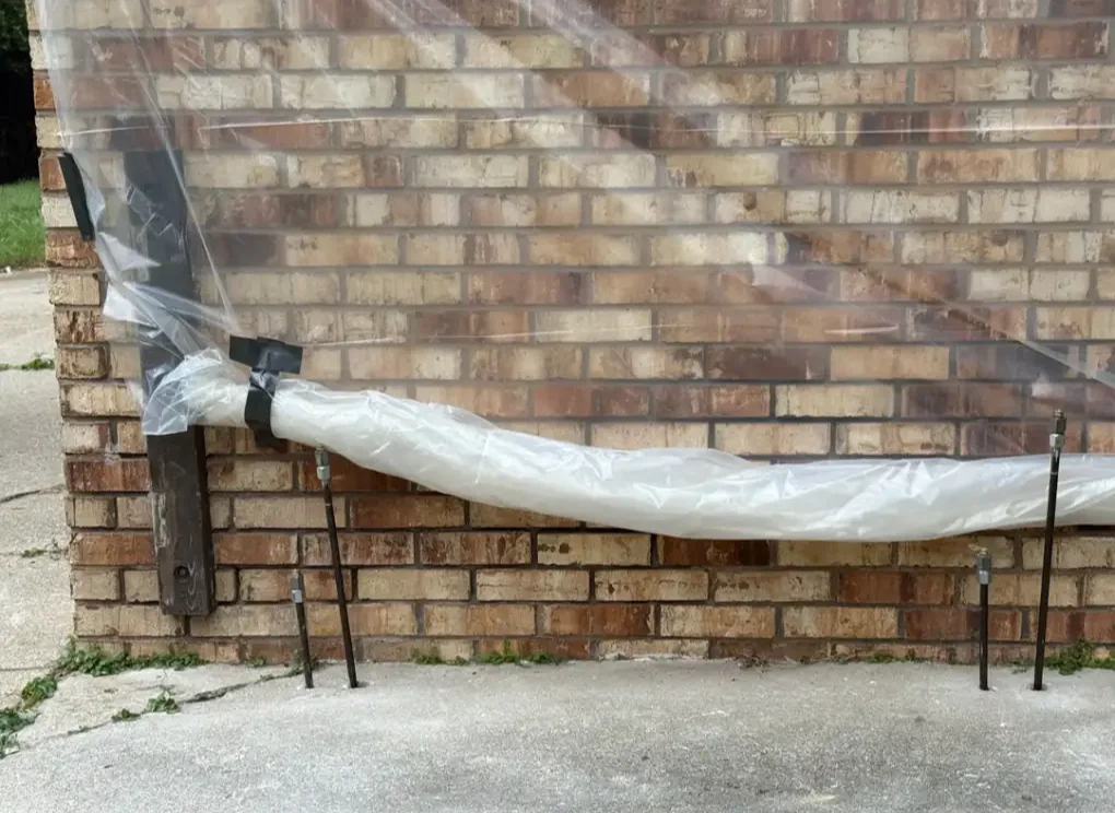Deep injection rods installed along an exterior foundation wall for soil stabilization