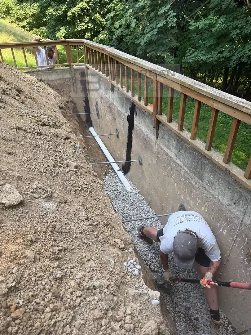 New drain tile and drainage stone at the footing of a retaining wall in Farmington Hills MI
