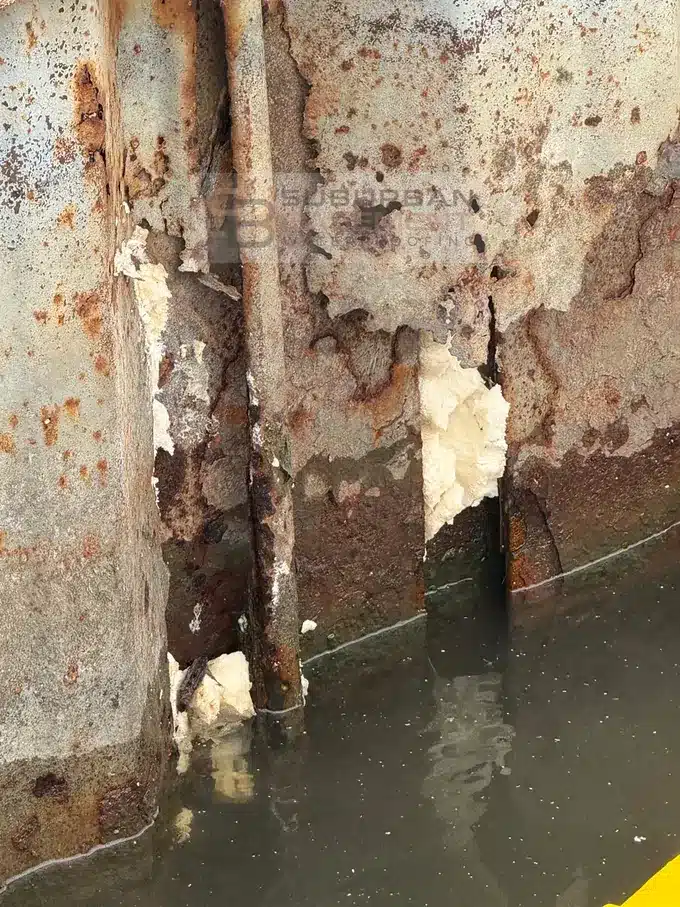Polyurethane grout filling seams and holes in a steel canal seawall in Harrison Township MI