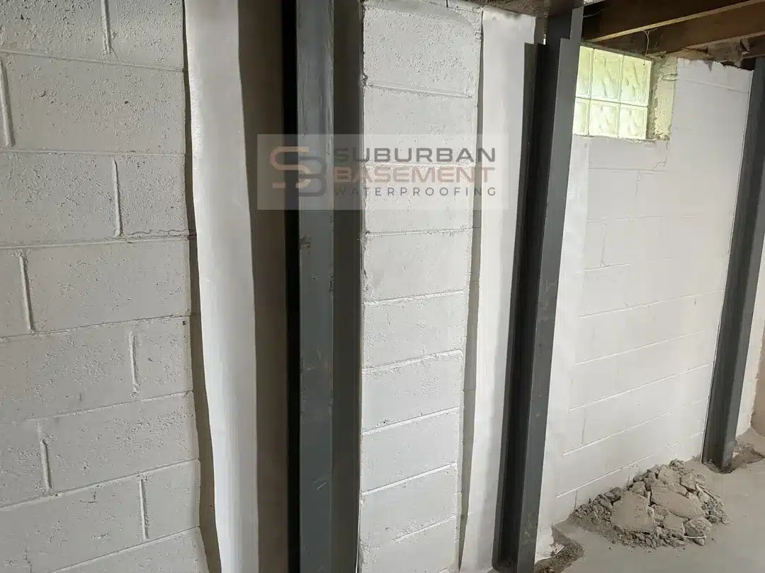 Woven vapor barrier installed behind steel beam locations on a basement wall in Ferndale MI